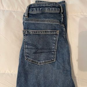 Dark wash stretch American Eagle jeans w/ holes.